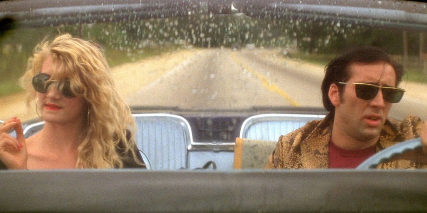 Nicolas Cage and Laura Dern driving in a car on an empty road in Wild at Heart