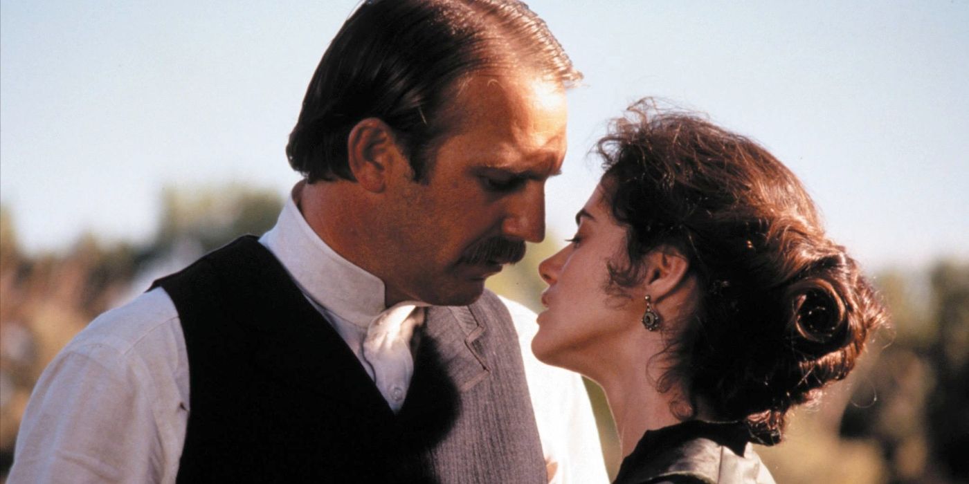 Kevin Costner and Joanna Going as Wyatt Earp and Josie Marcus leaning in to kiss in Wyatt Earp