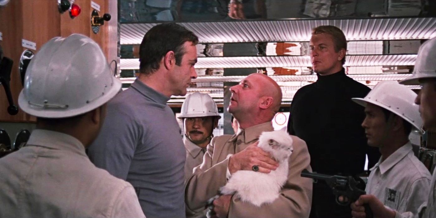 James Bond (Sean Connery) confront Blofeld (Donald Pleasance) who pats his cat as armed men surround them.
