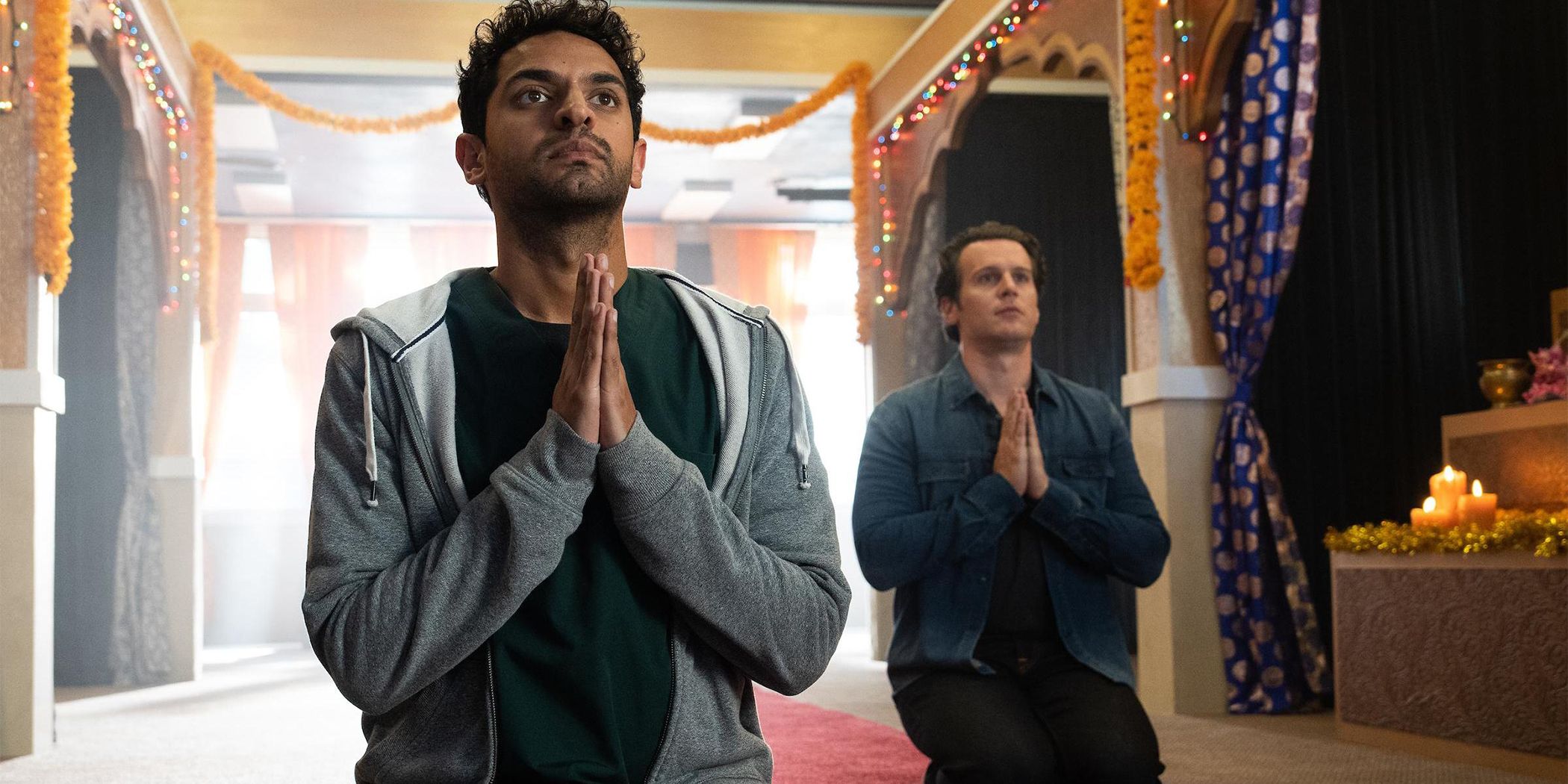 Karan Soni y Jonathan Groff se arrodillan en oración 