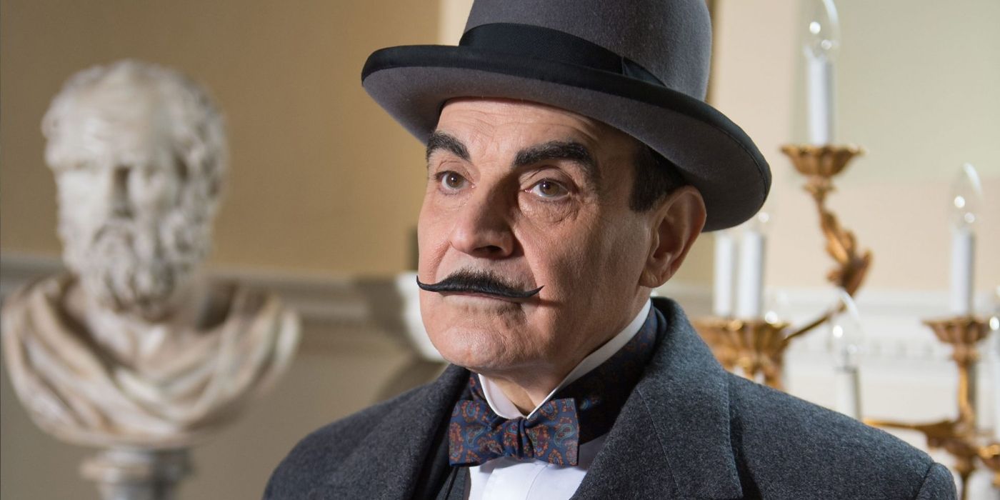 David Suchet as Hercule Poirot, standing in front of a bust and a candelabra in Agatha Christie's Poirot