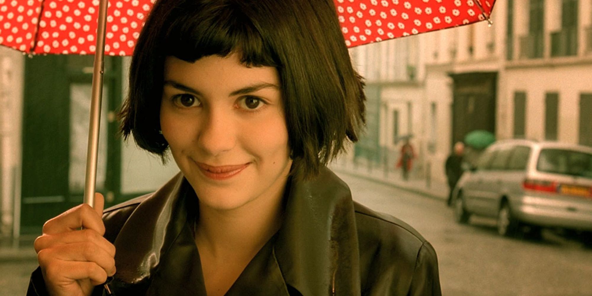 Amelie smiling under an umbrella