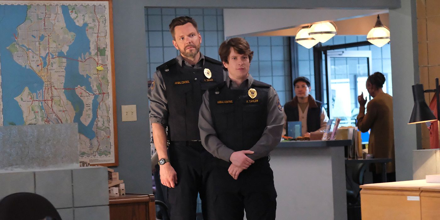 Joel McHale stands behind his co-star Michael Rowland in a scene from Animal Control Season 2.