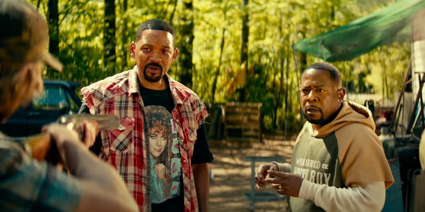 Will Smith as Mike Lowrey wearing a Reba shirt and Martin Lawrence as Marcus Burnett, with a shotgun pointed at them, in Bad Boys: Ride or Die.
