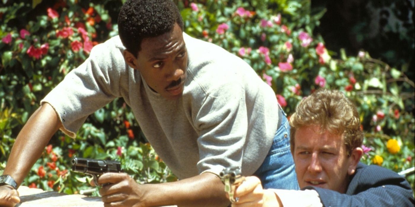 Eddie Murphy and Judge Reinhold hide behind a bush in Beverly Hills Cop 