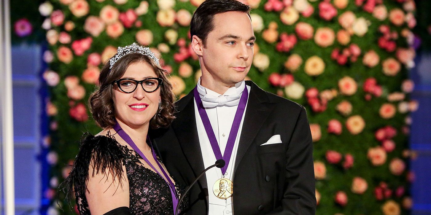 Jim Parsons and Mayim Bialik as Sheldon and Amy, smiling while receiving their Nobel Prize 