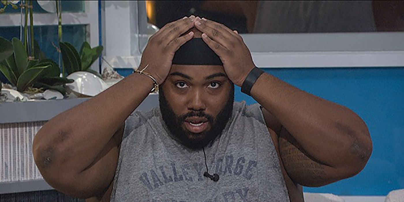 Derek F from Big Brother with his hands on his head, looking shocked.