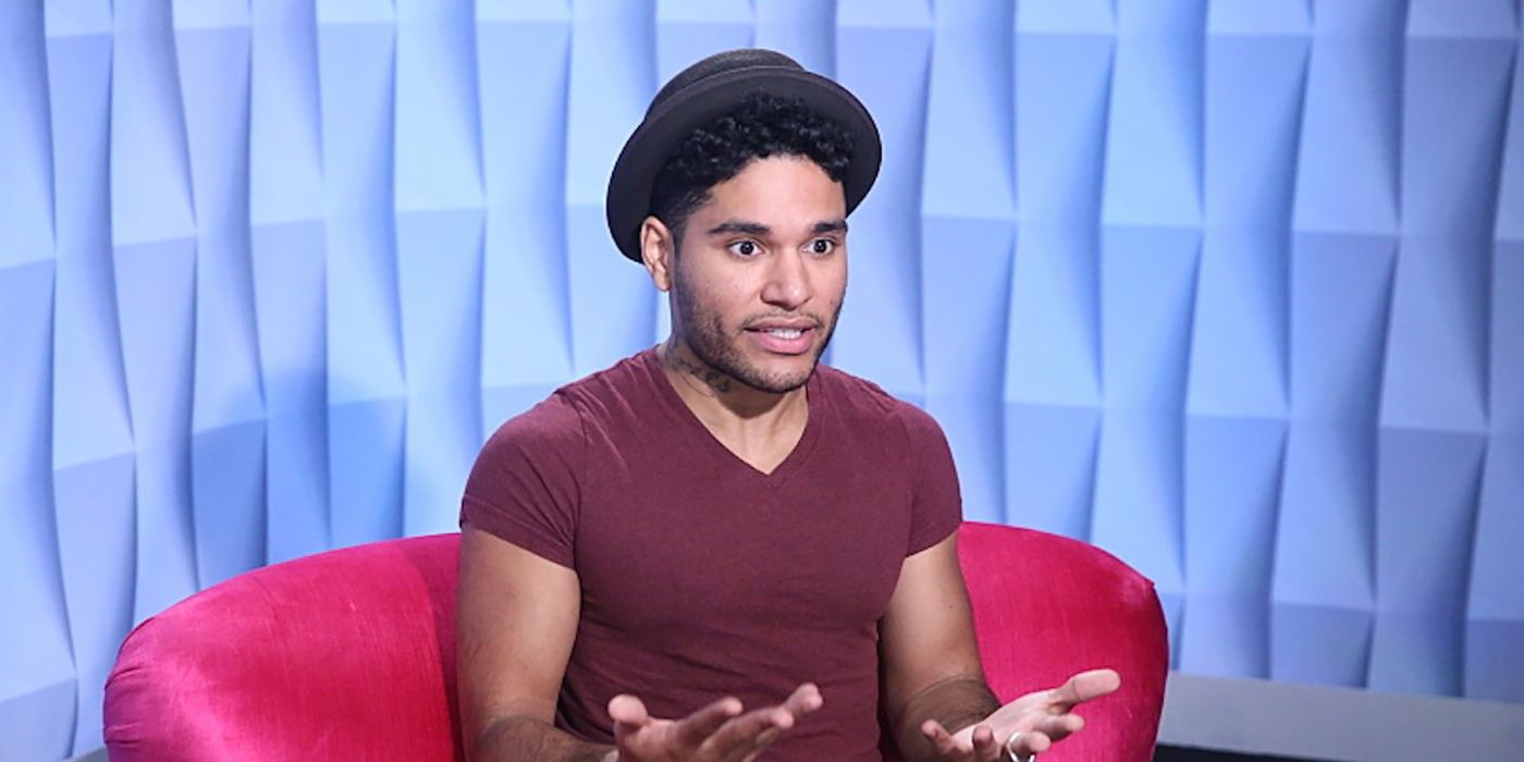 Jozea in the diary room in Big Brother wearing a hat, hands out talking.
