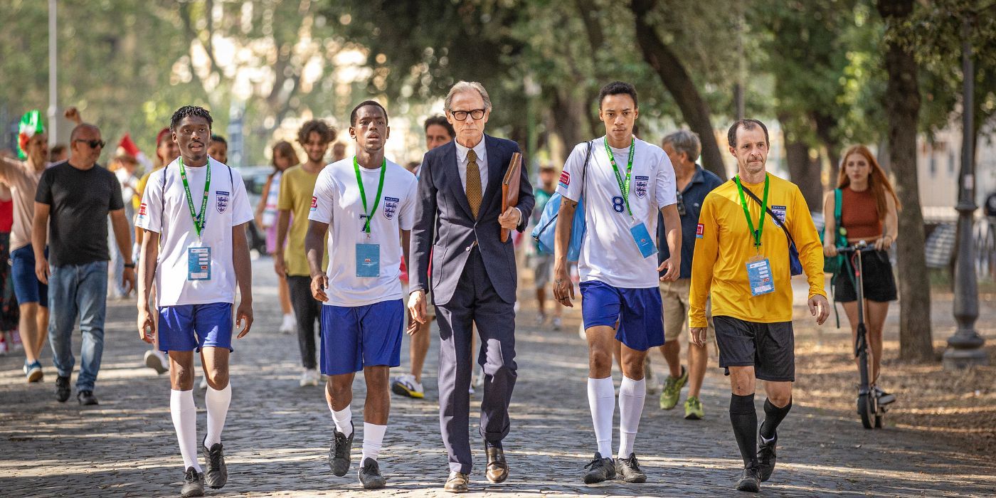 Bill Nighy, Michael Ward, Kit Ward, Sheyi Cole, Tom Vaughan-Lawlor walk together in The Beautiful Game.