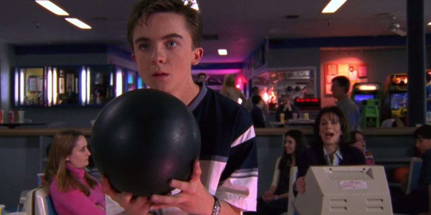 Malcolm holds a bowling ball as his mother cheers him on in the background