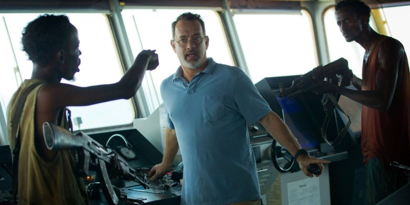 Muse and another pirate surround Captain Phillips in the film Captain Phillips