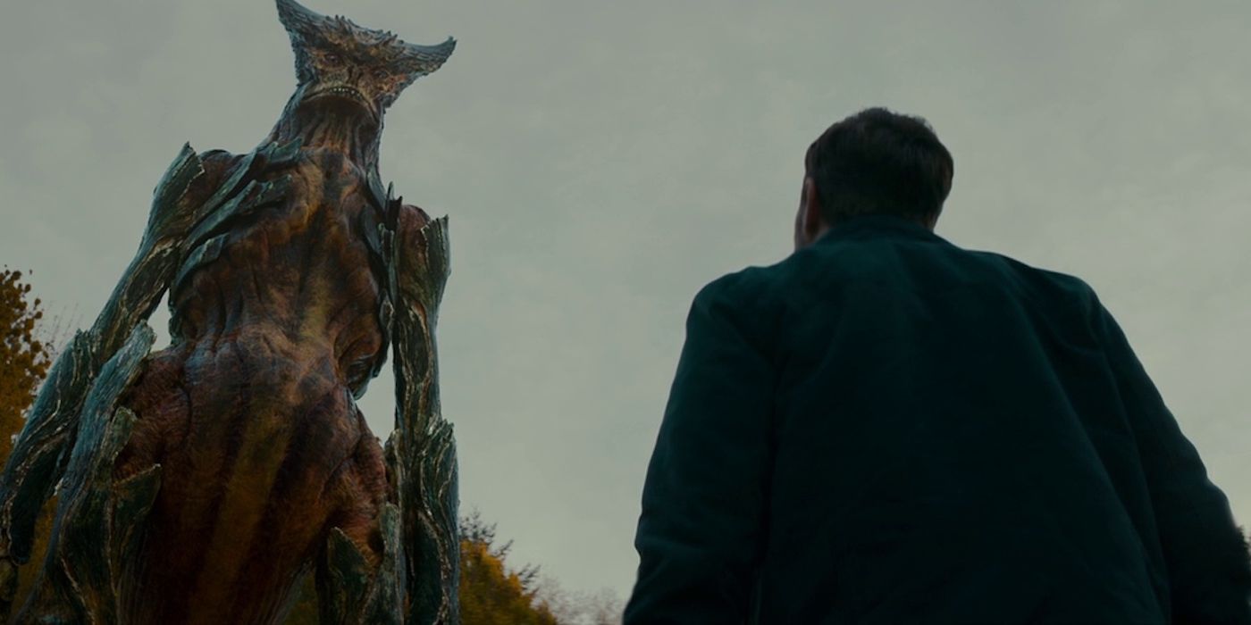 A man looking at a giant monster approaching in the film Colossal