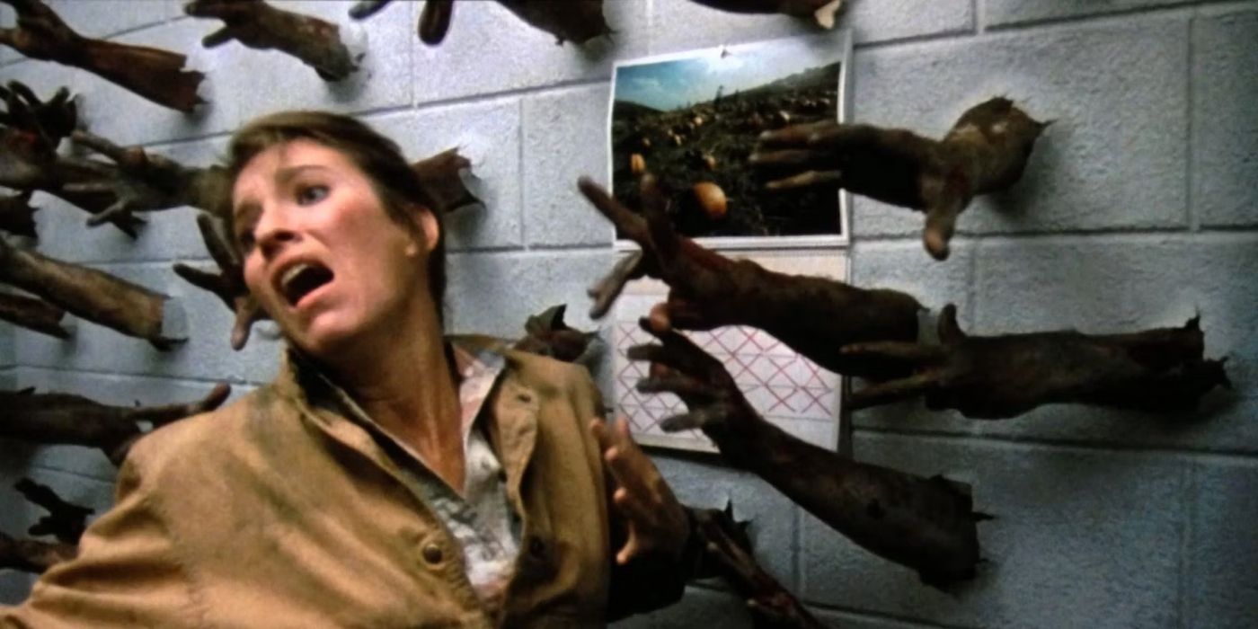 A woman screaming in fear while zombie hands break through a wall in Day-of-the-Dead