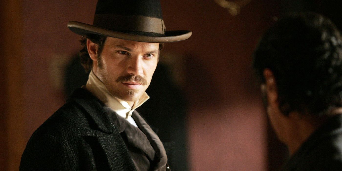 Timothy Olyphant in Deadwood wearing a hat and looking menacingly at someone.