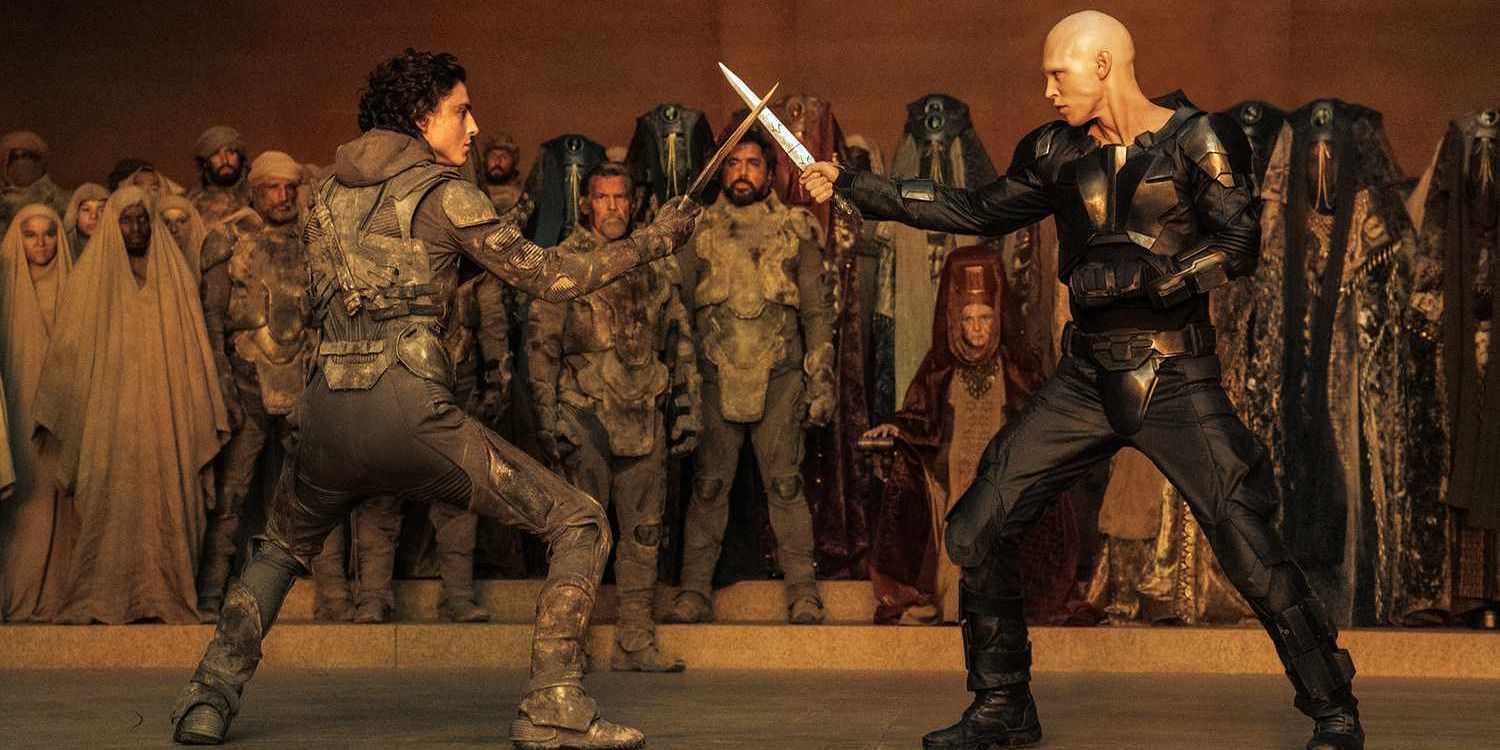     Feyd-Rautha (Austin Butler) and Paul Atreides (Timothee Chalamet) face off with knives while a crowd watches on in 'Dune: Part Two'