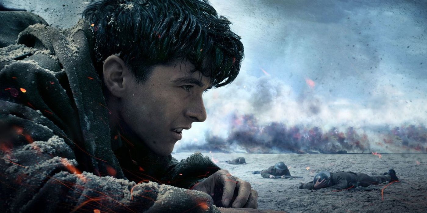 Fionn Whitehead as Tommy, crawling on a beach surrounded by smoke and other soldiers in Dunkirk