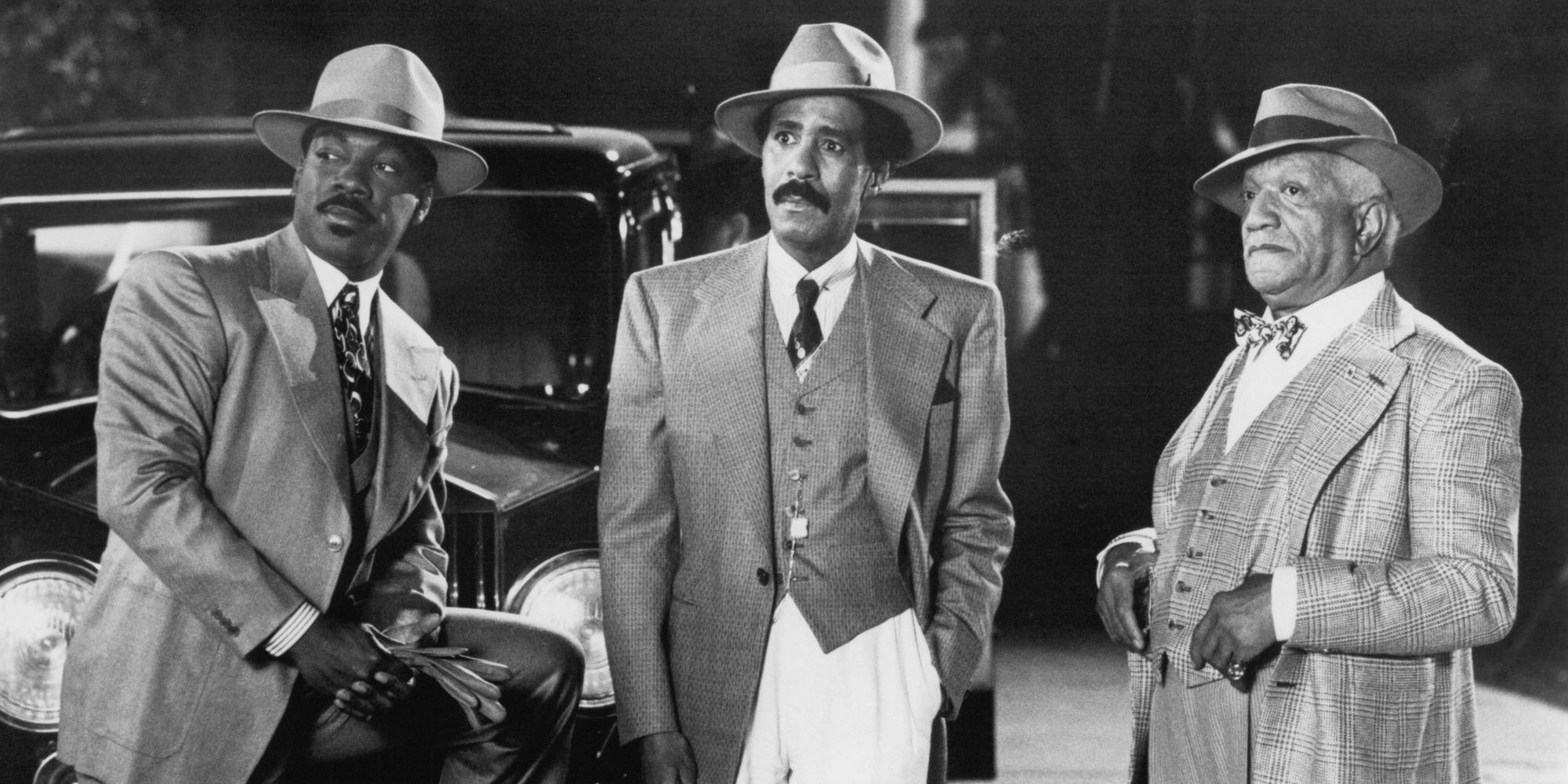 Eddie Murphy, Richard Pryor and Redd Fox leaning against a vehicle in Harlem Nights