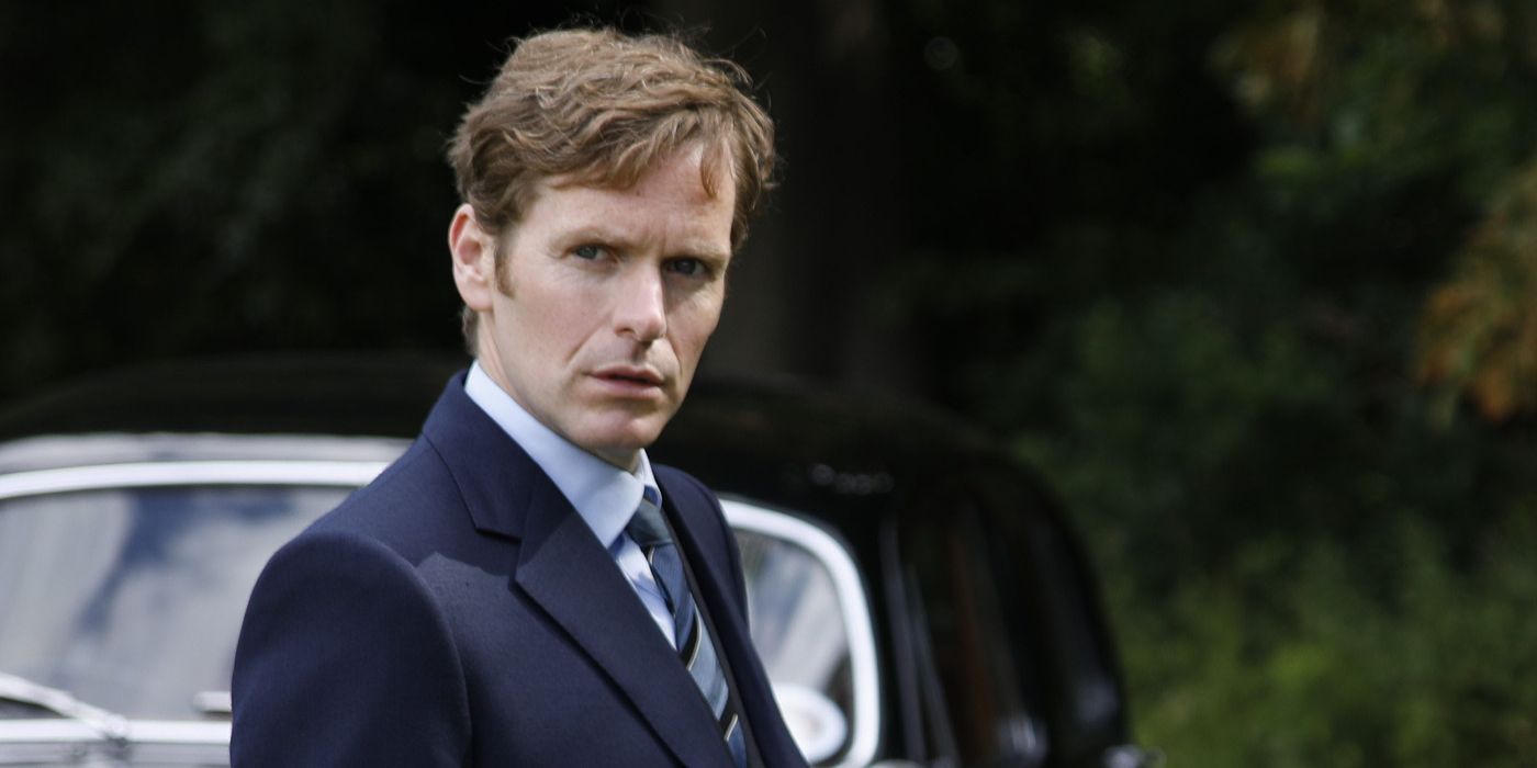 Endeavour Morse (Shaun Evans) stands by his black car with an inquisitive expression.