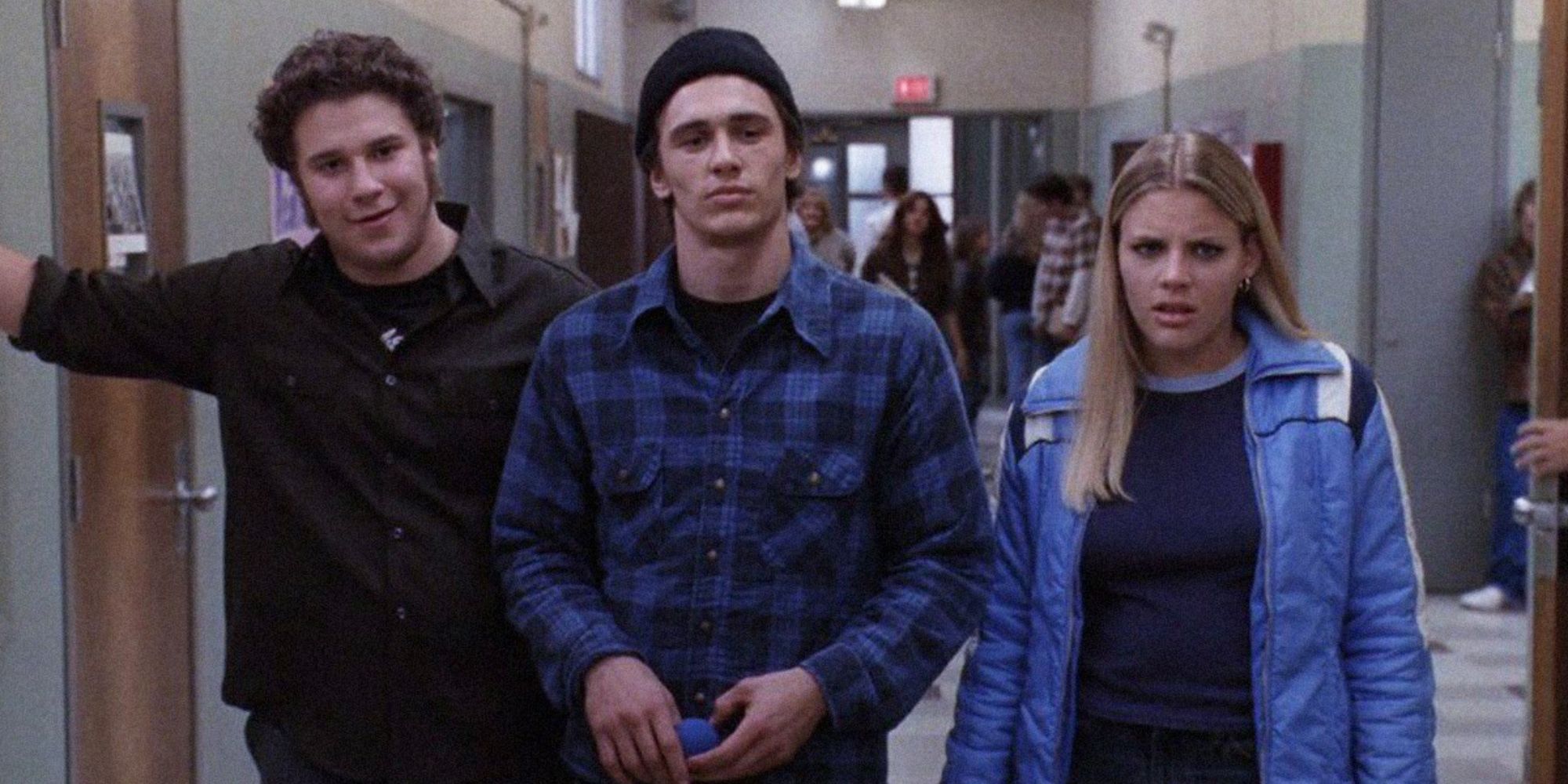 The Freaks and Lindsay from Freaks & Geeks standing together walking down the hallway in school.