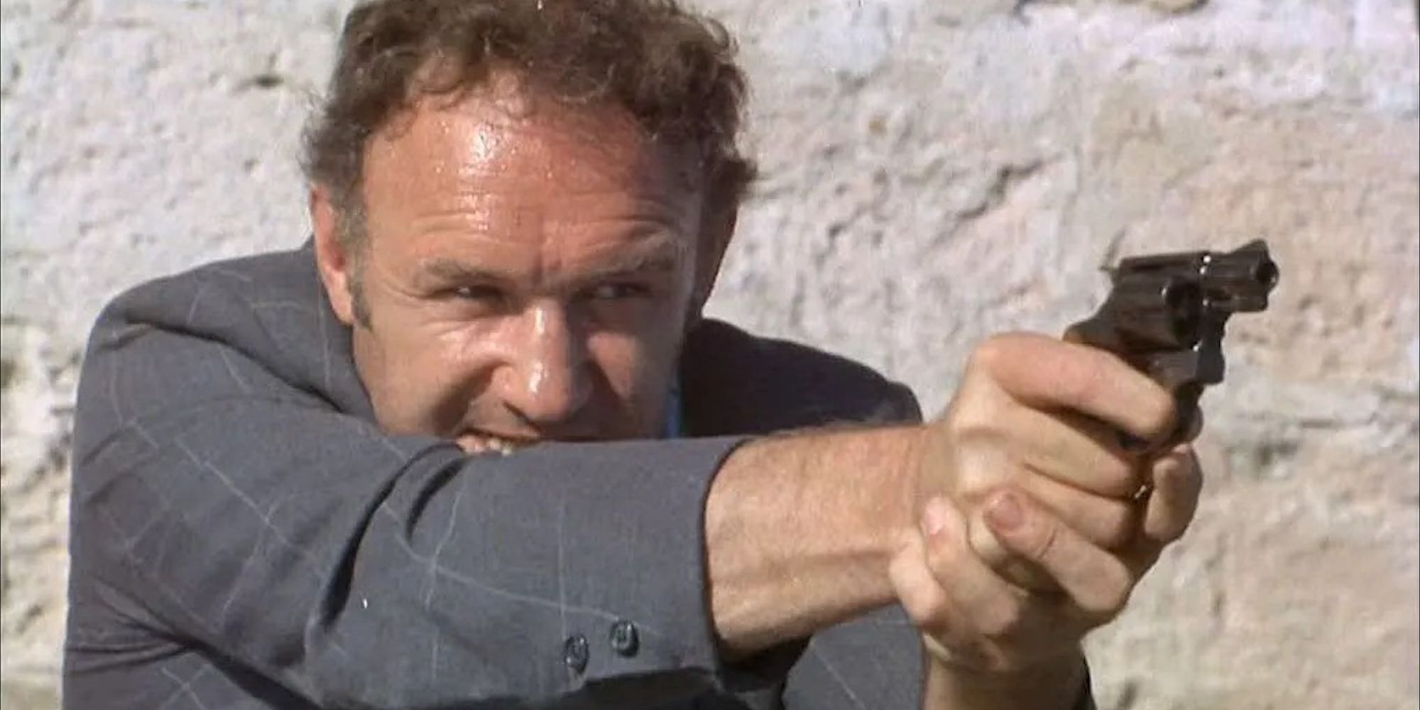 Gene Hackman as Jimmy "Popeye" Doyle, aiming a handgun in The French Connection