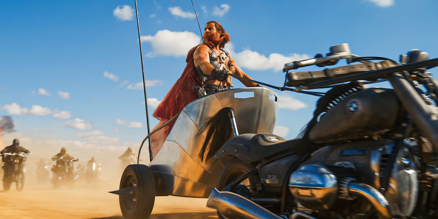 Chris Hemsworth riding a massive bike and wearing a cape in Furiosa: A Mad Max Saga