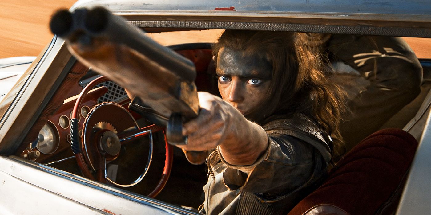 Furiosa driving a car while aiming a gun at someone off-camera in Furiosa: A Mad Max Saga