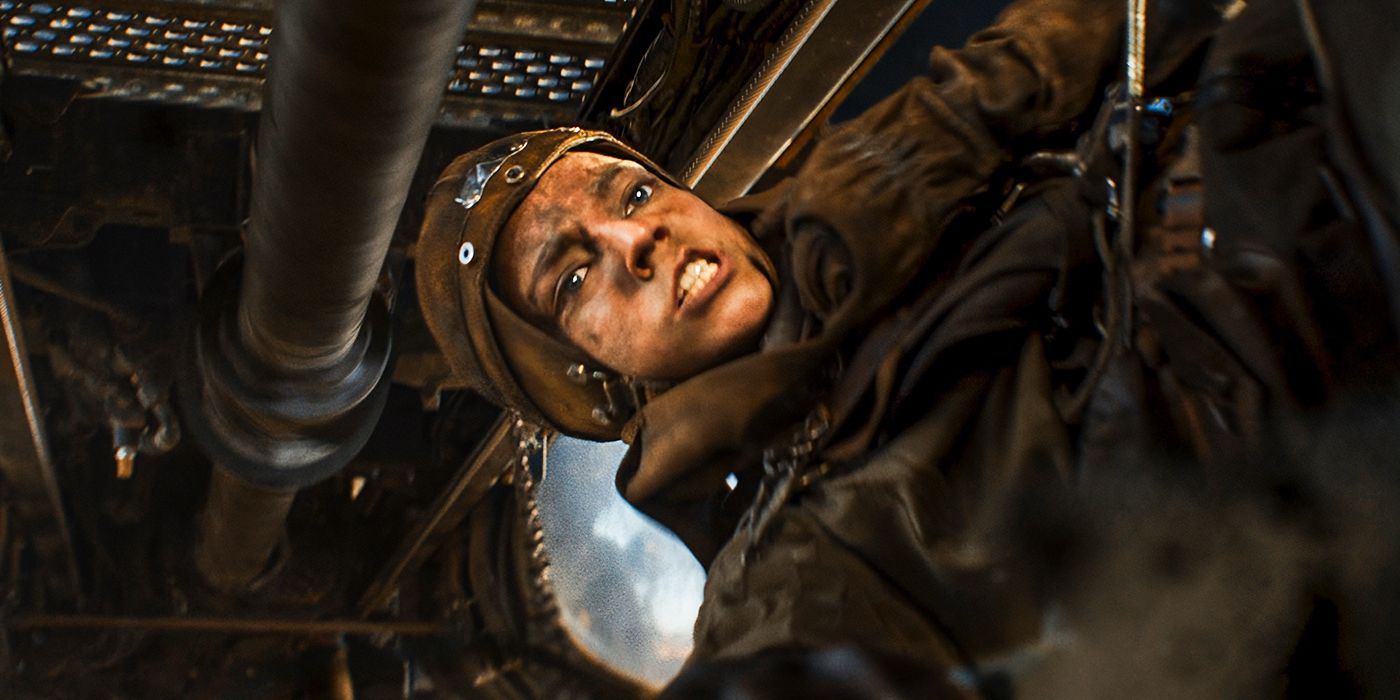 Anya Taylor Joy hanging under a vehicle in Furiosa: A Mad Max Saga