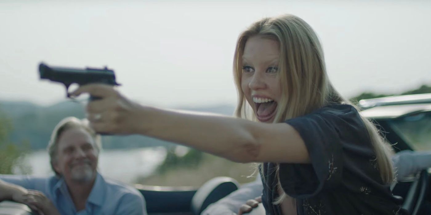 Gabi Bauer holding a gun with a maniacal smile Infinity Pool