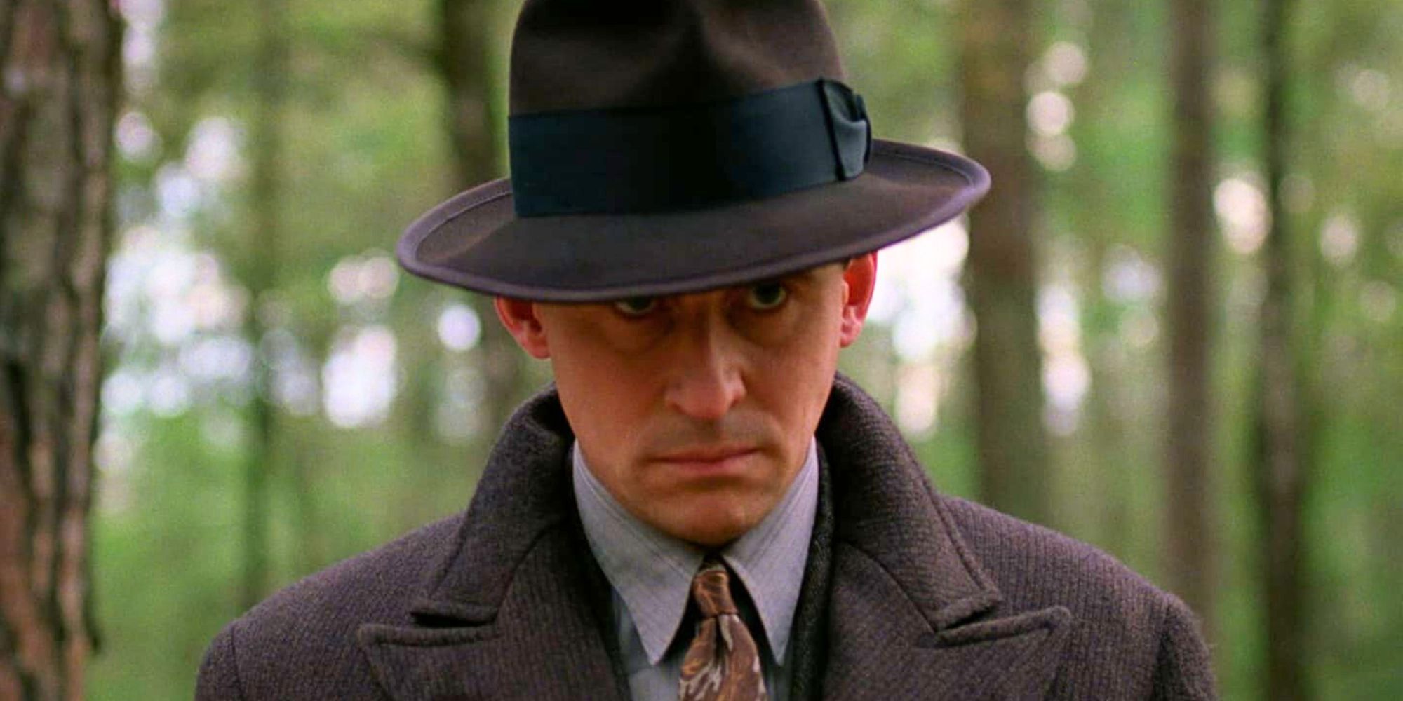 Gabriel Byrne standing alone in the woods peering up in Miller&rsquo;s Crossing (1990)