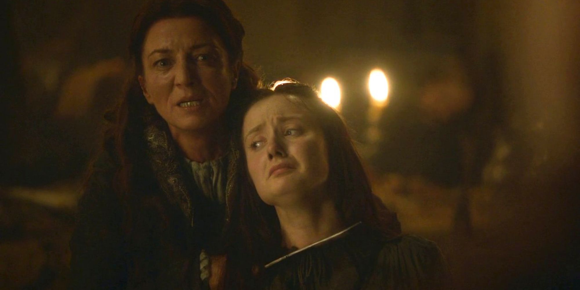 A woman holds another woman by the hair and holds a dagger to her throat in Game of Thrones.