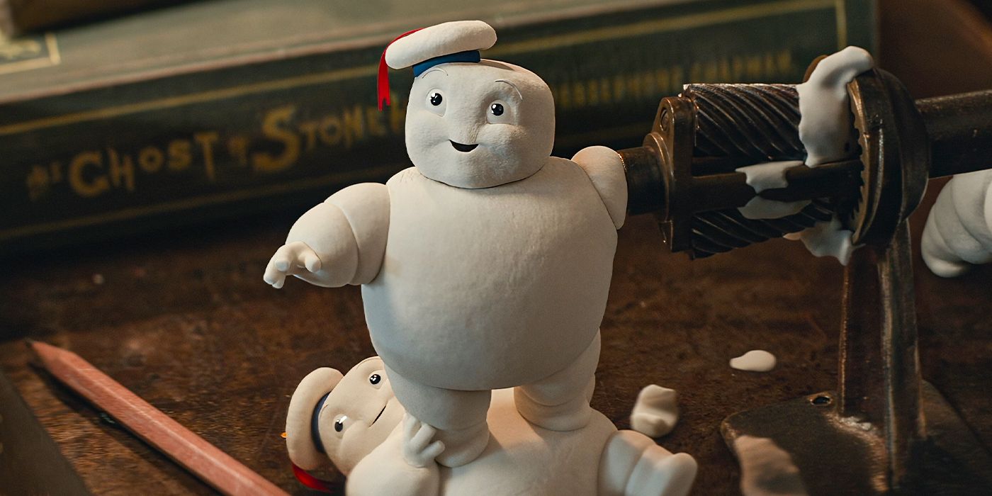A Mini-Puft marshmallow grinds his arm in a pencil sharpener, smiling & standing atop another Mini-Puft