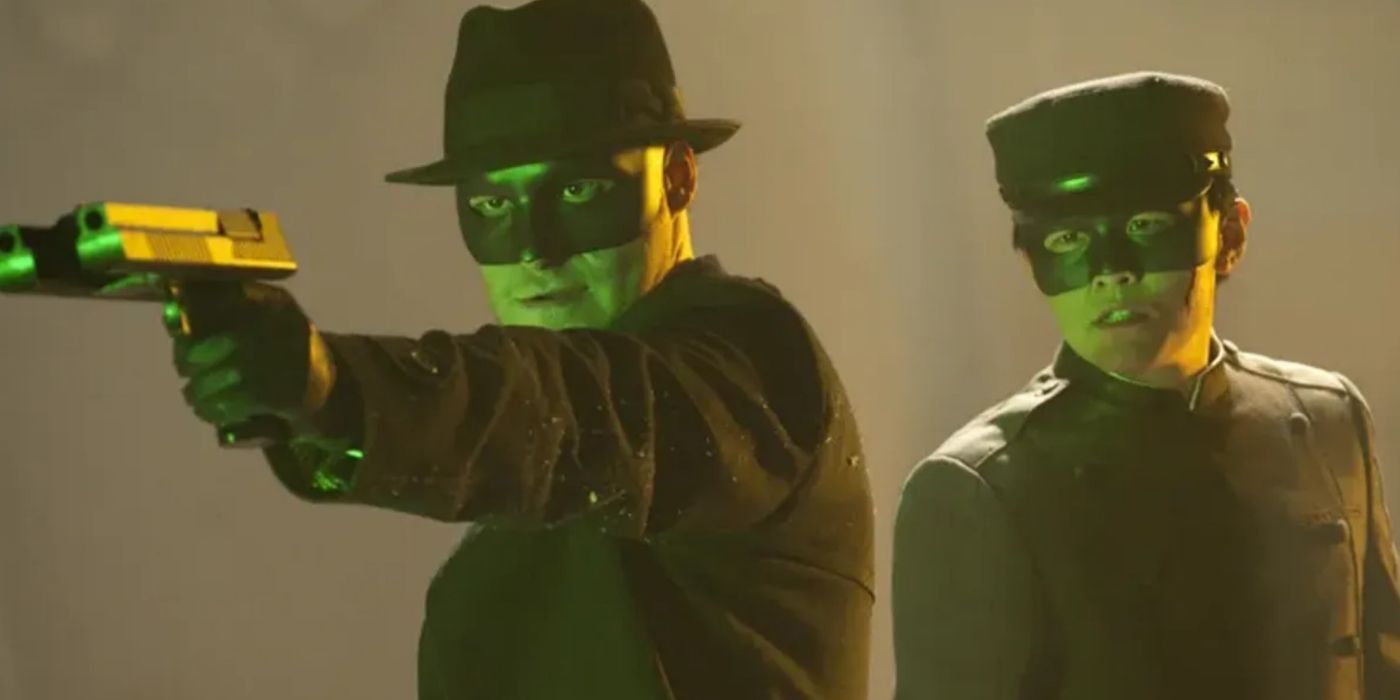 Seth Rogen pointing a gun at a person offscreen while standing beside Jay Chou in 'The Green Hornet'