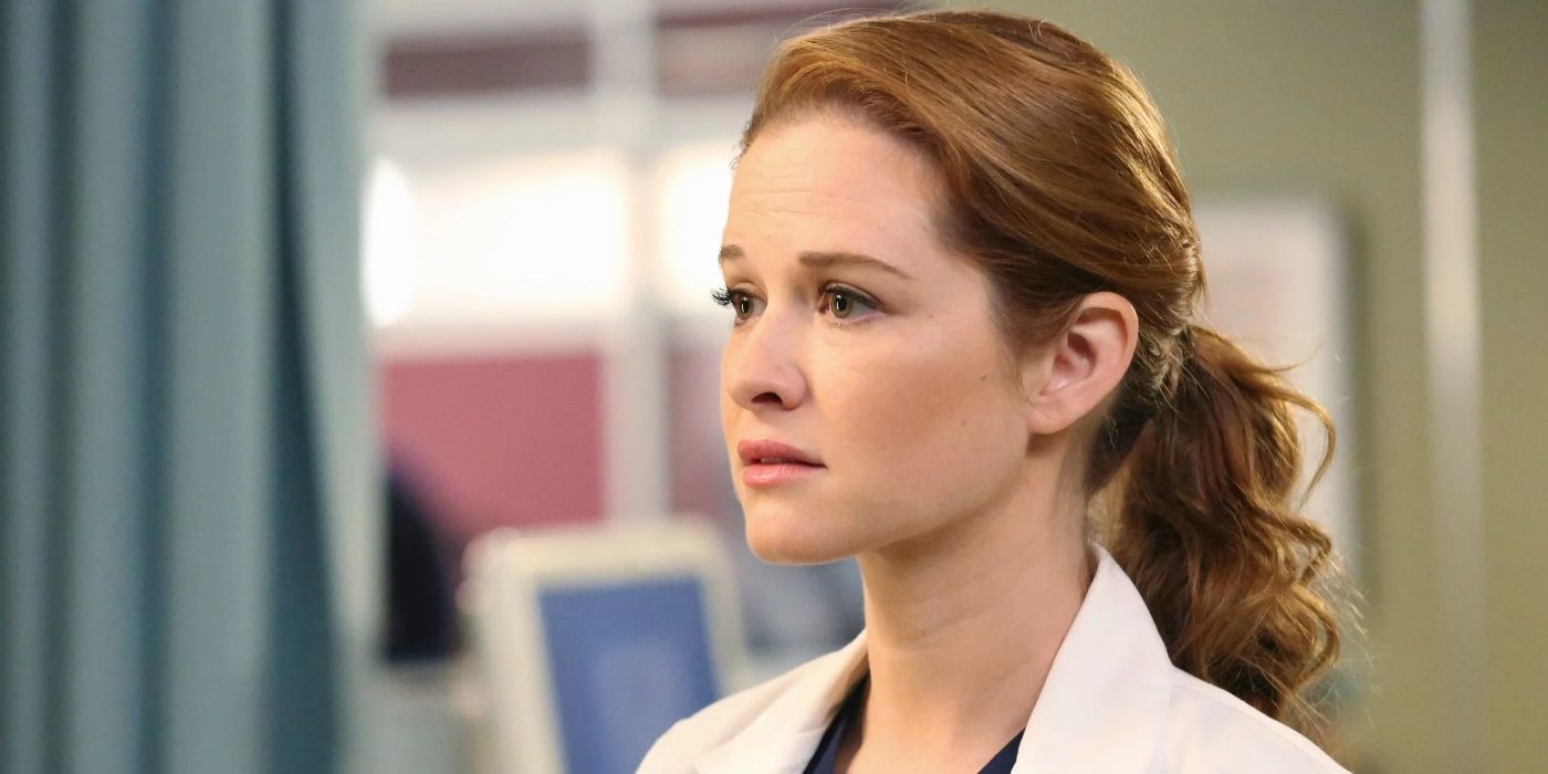 Sarah Drew as April Kepner, standing in the emergency room looking sad on Grey's Anatomy