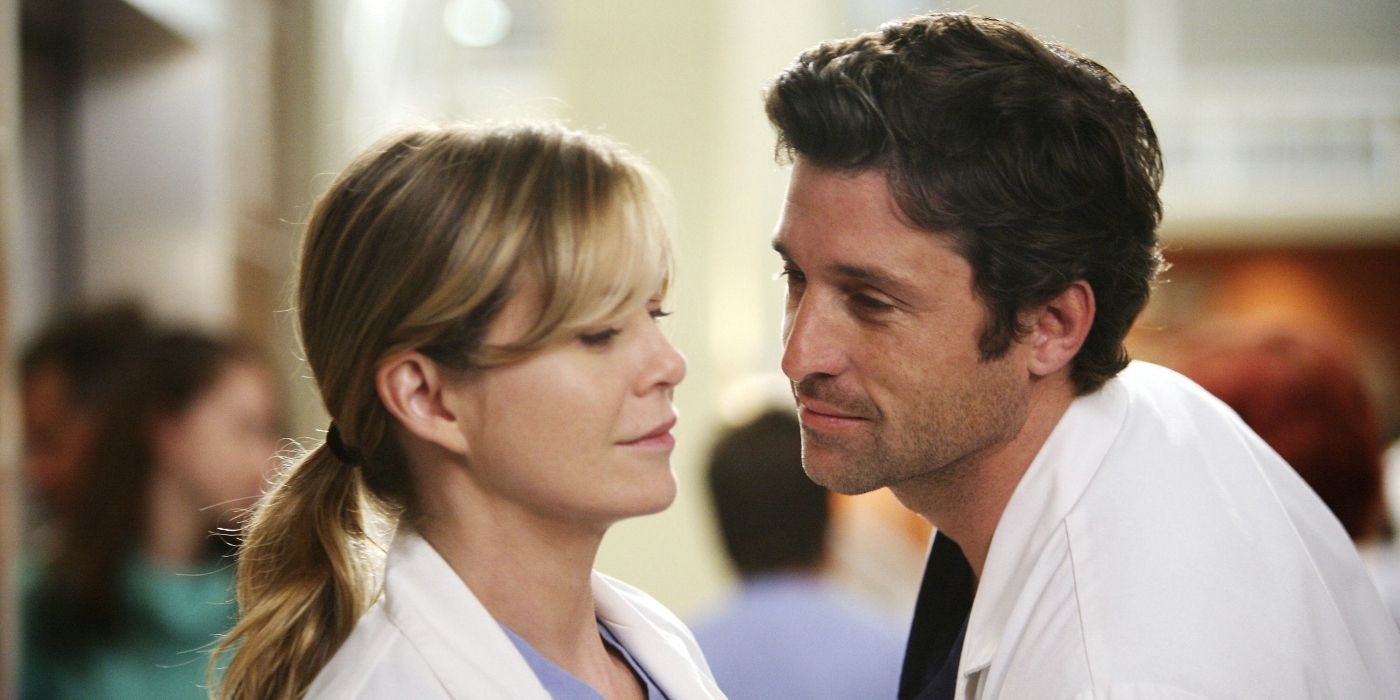 Patrick Dempsey and Ellen Pompeo as Derek Shepherd and Meredith Grey, standing near each other and smiling in Grey's Anatomy