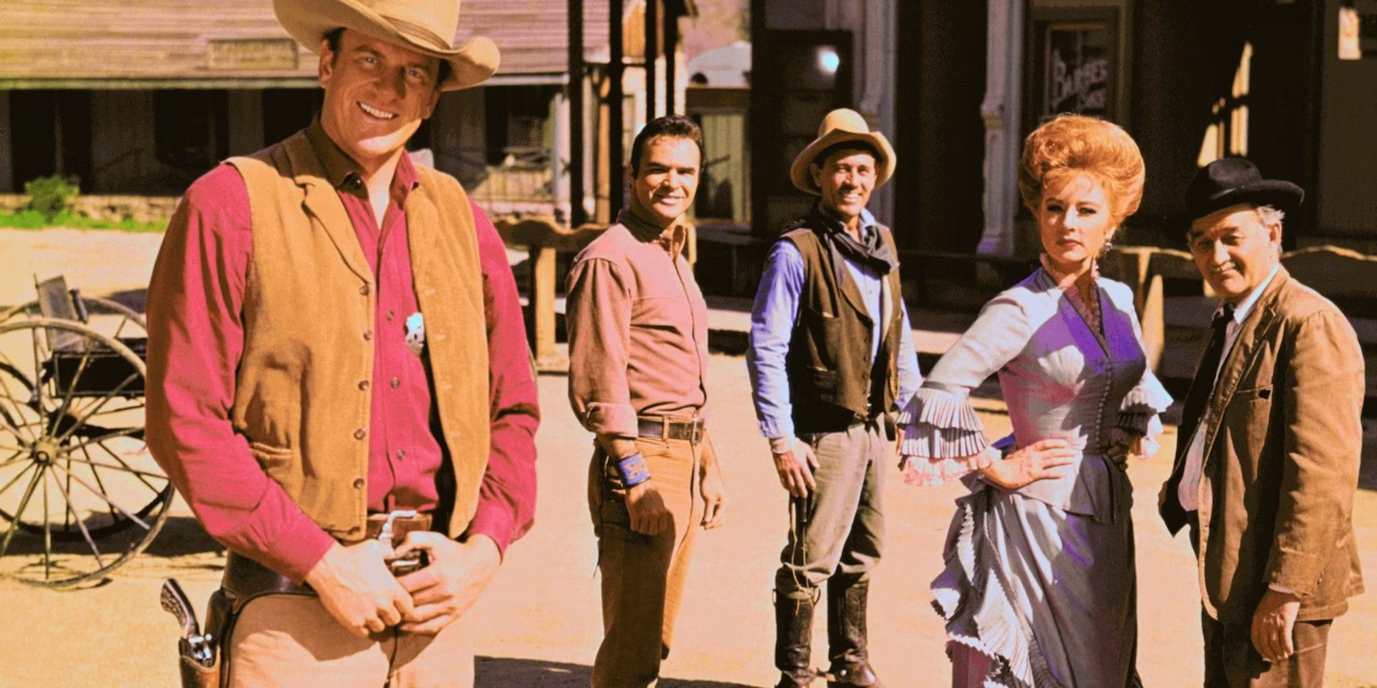 The cast of Gunsmoke standing outside in the town square.