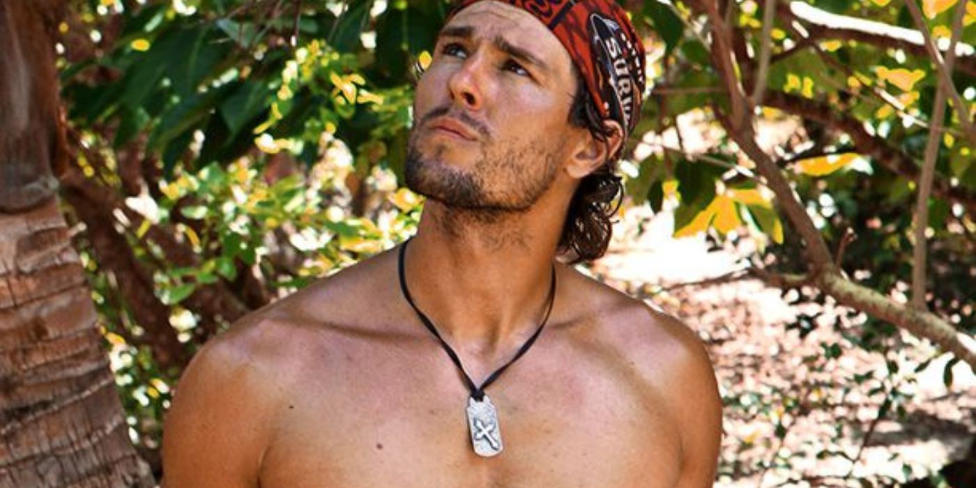 Hayden Moss with a bandanna on looking up at something with a jungle behind on Survivor: Blood vs Water.