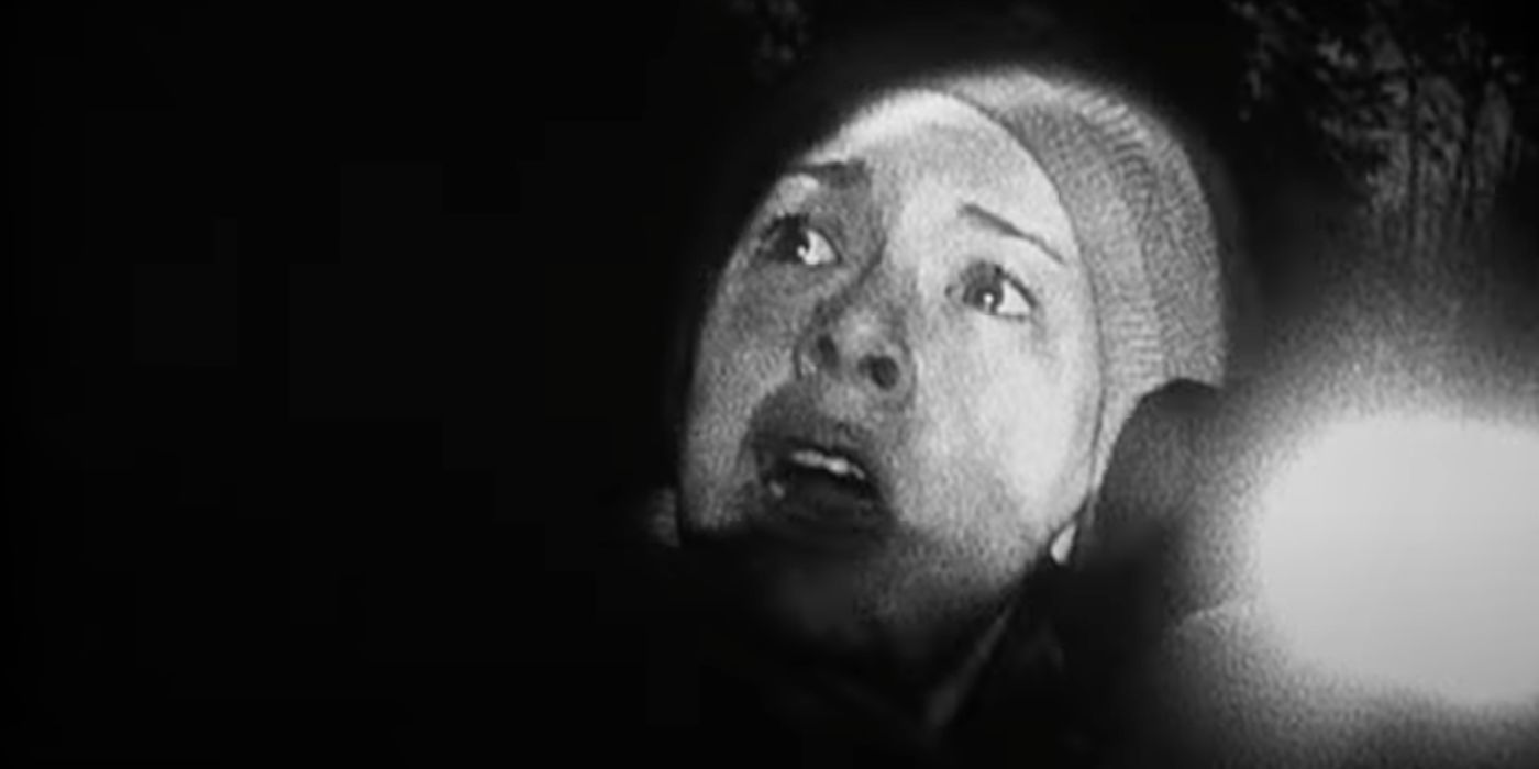 Heather Donahue looking scared in the woods in The Blair Witch Project (1999).