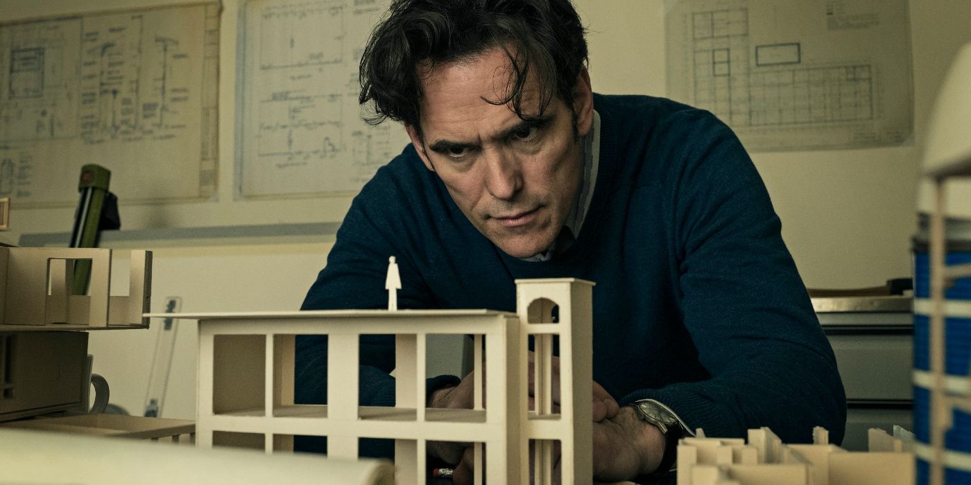 Matt Dillon as Jack, looking at a miniature of a house in The House That Jack Built