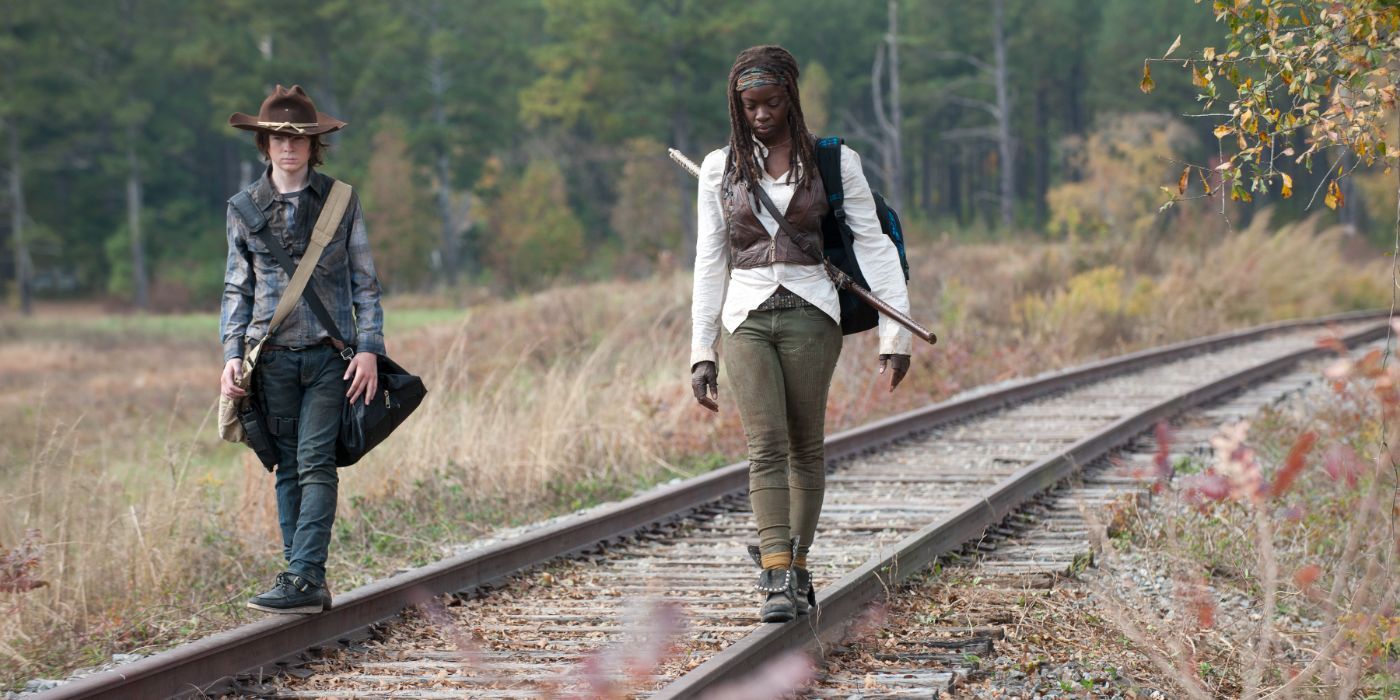 Danai Gurira as Michonne and Chandler Riggs as Carl walking on railways to Terminus in The Walking Dead.