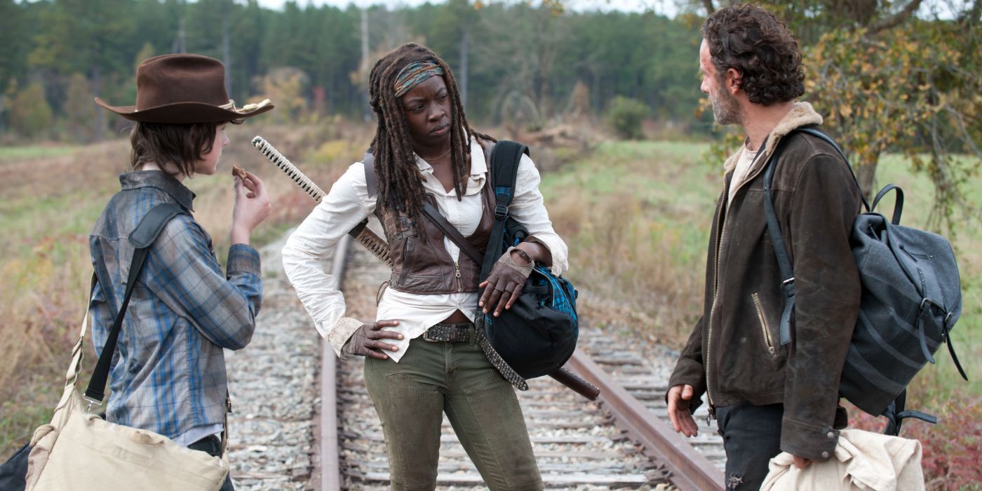 Andrew Lincoln as Rick, Danai Gurira as Michonne and Chandler Riggs as Carl have a discussion on train tracks in The Walking Dead.