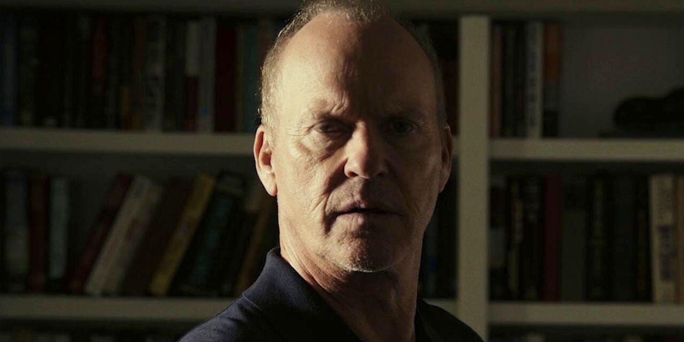 Michael Keaton as John Knox standing in front of a bookshelf in Knox Goes Away.