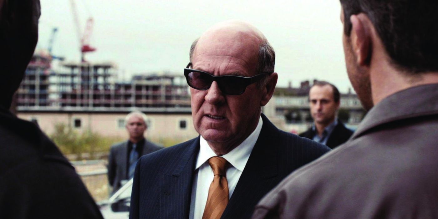 Lenny Cole (Tom Wilkinson) confronts two of his goons as he is backed by his criminal lieutenants in 'RocknRolla' (2008)