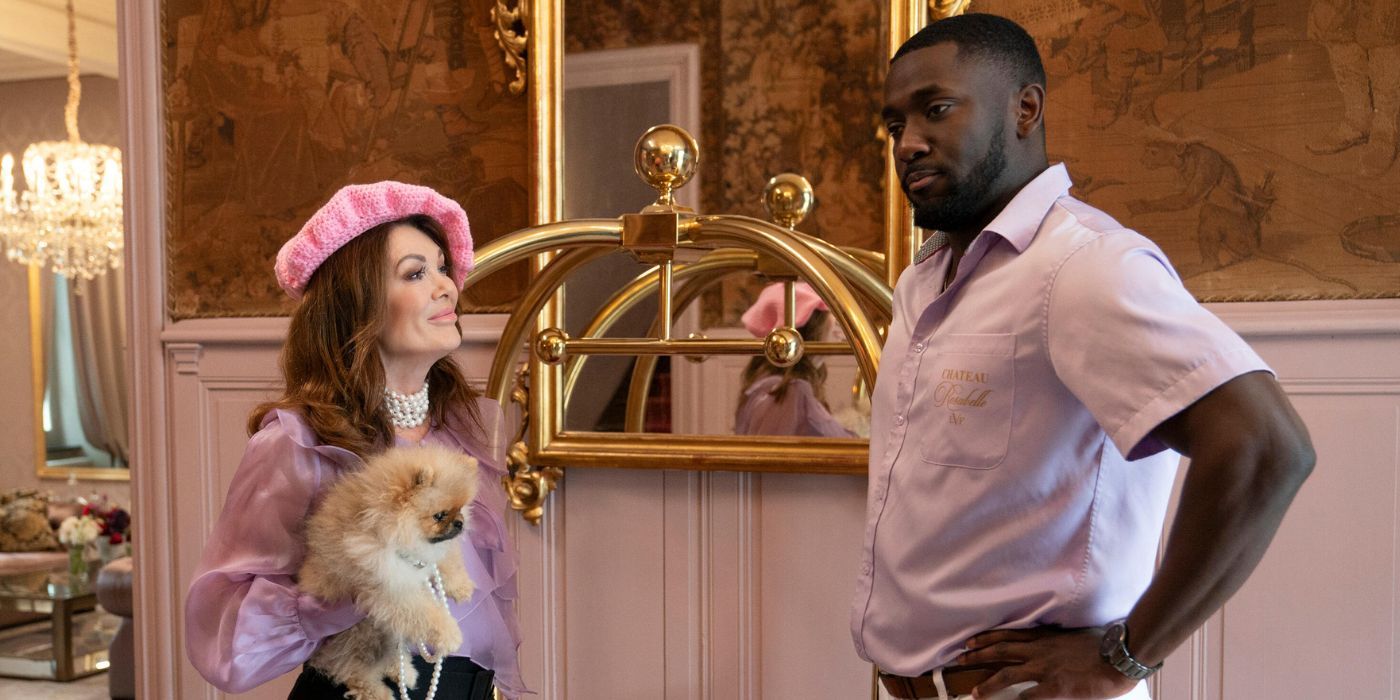 Lisa Vanderpump sostiene un perro mientras charla con Andre Mitchell en 'Vanderpump Villa'