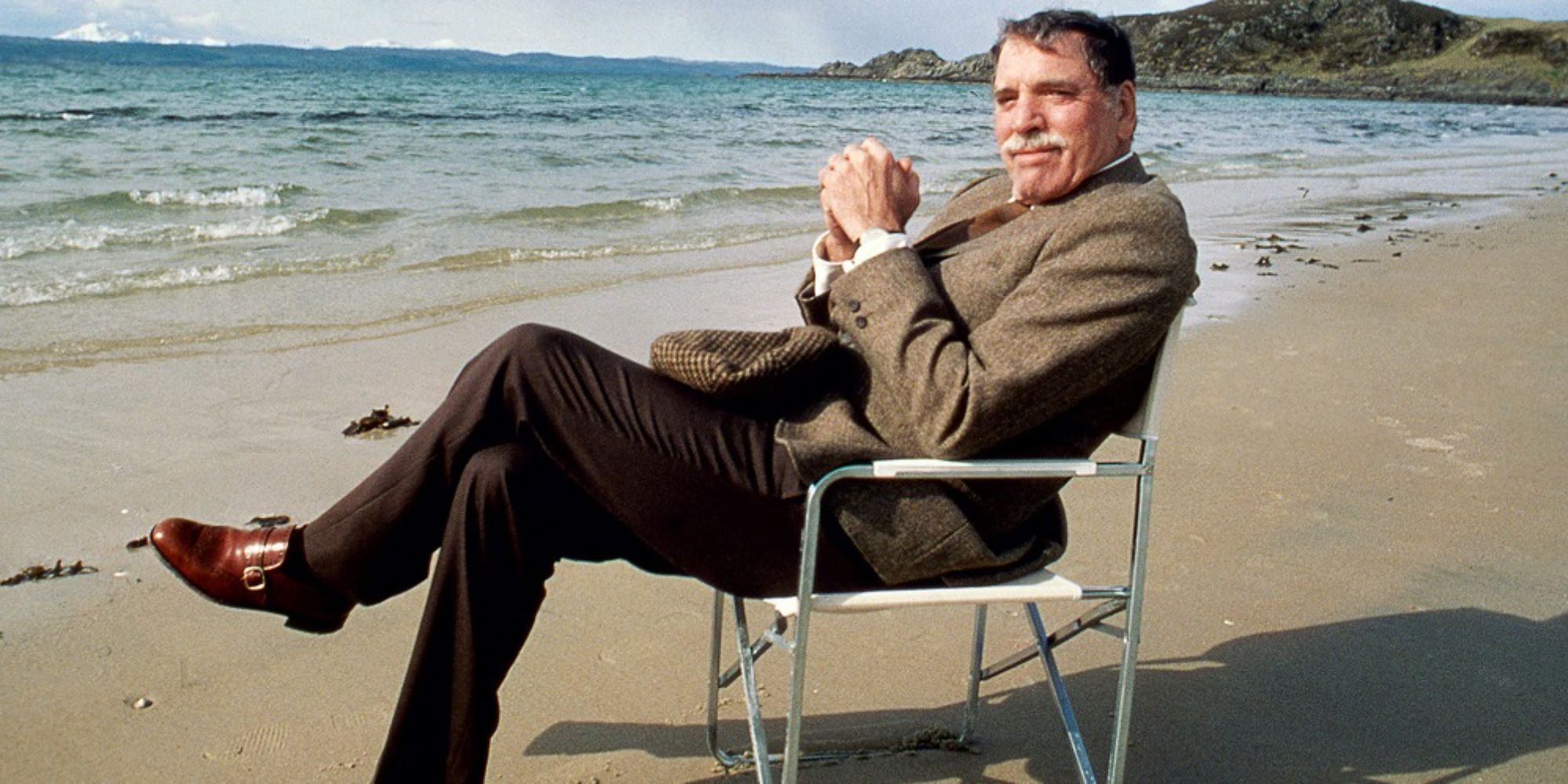 A man sitting on the chair on the beach in Local Hero