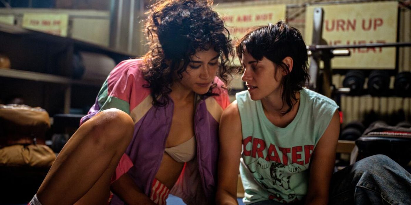 Jackie (Katy M. O'Brien) sits on the floor beside Lou (Kristen Stewart) in a gym in 'Love Lies Bleeding' (2024)