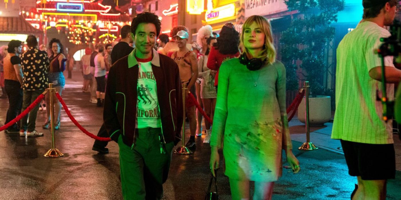 Justin Min walking with his hands on his pocket next to Lucy Boynton in 'The Greatest Hits'