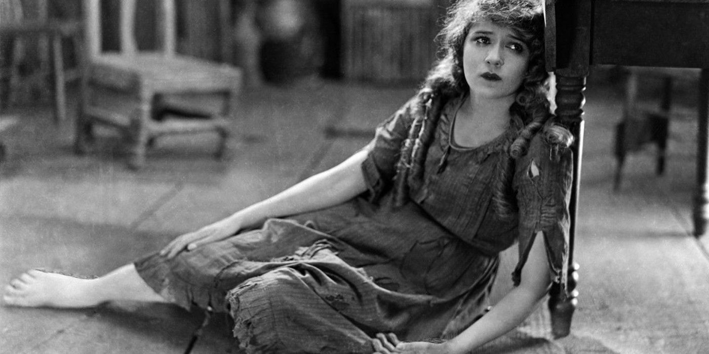 Mary Pickford as Tessibel Skinner sitting on the floor and leaning on a table in 'Tess of the Storm Country'