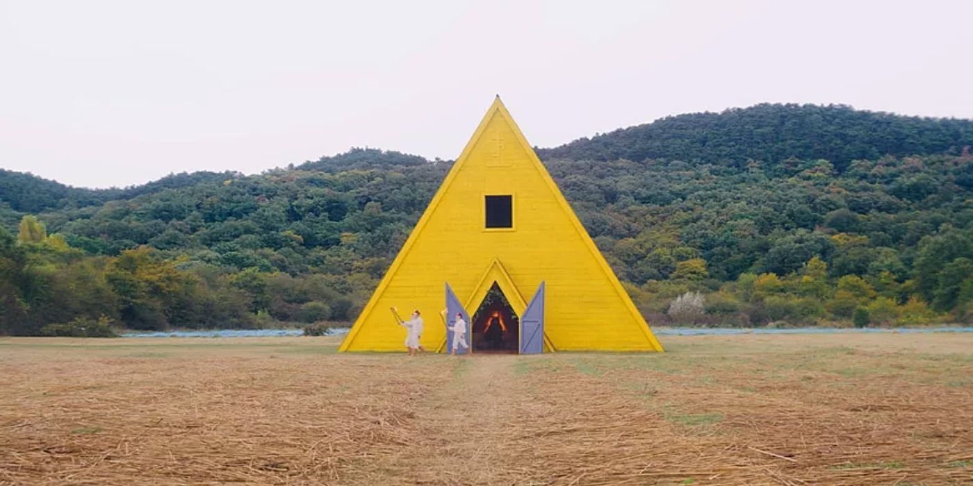 A yellow building in the middle of an open field in Midsommar.