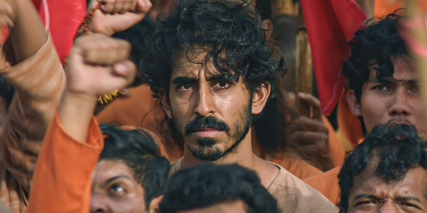 Dev Patel frowns at something while in a crowd in Monkey Man