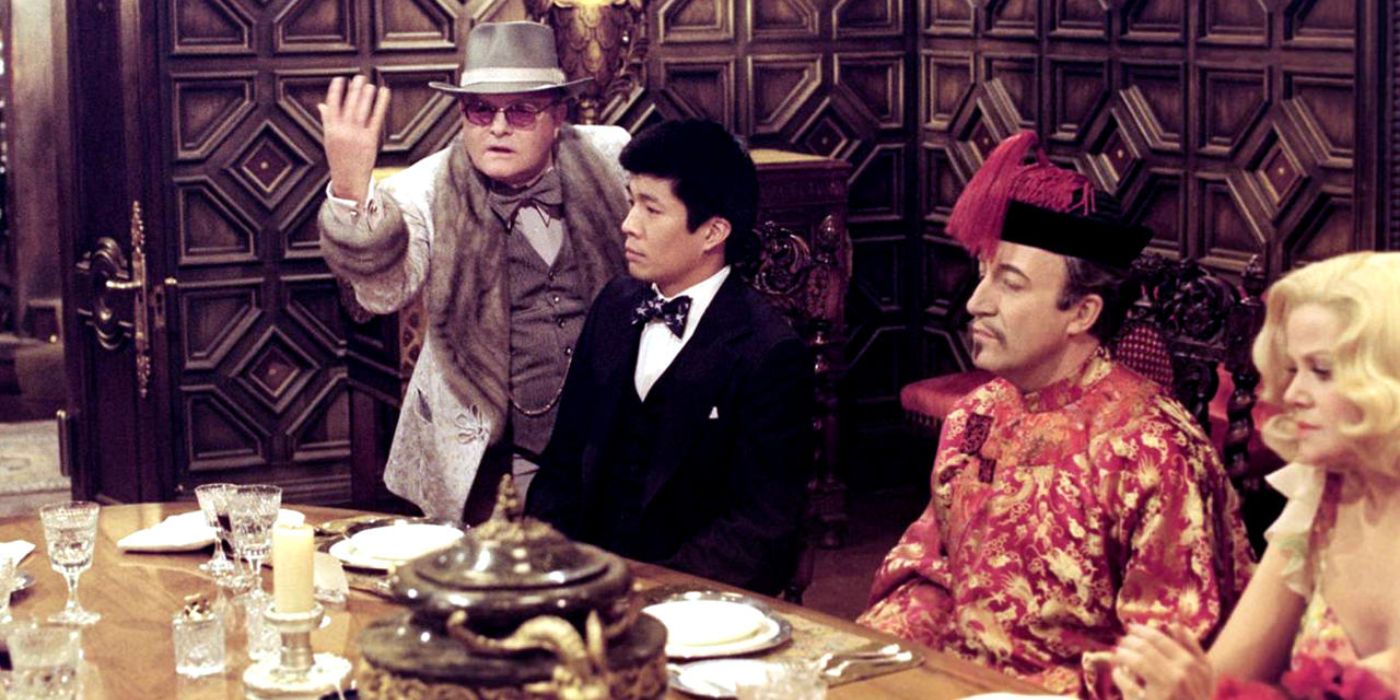 A detective plays out a scene for onlookers at a dinner party in 'Murder by Death' (1976).